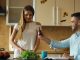 Attractive couple in the kitchen early morning cooking and have online video chat using tablet computer camera at home